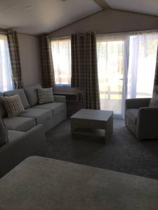 a living room with a couch and a coffee table at Sterlochy lodge in Boat of Garten