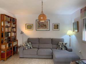een woonkamer met een bank en een boekenplank bij Mi casa de Cádiz in Cádiz
