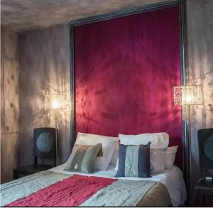 a bedroom with a large bed with a red headboard at Maison d'Aliénor in Taillebourg