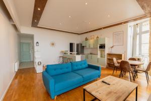 a living room with a blue couch and a table at - Le Saugeron - in Blaye