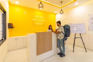 Ein Mann und eine Frau stehen an einer Theke in einem Raum in der Unterkunft The Social Stays Jaipur formerly ArtBuzz in Jaipur