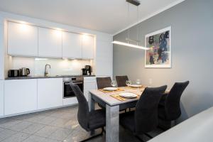 a kitchen and dining room with a table and chairs at Albatros EG in Tinnum