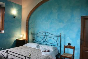 a blue bedroom with a bed and a chair at Villa Il Poggiarone in Montepulciano +22 photos