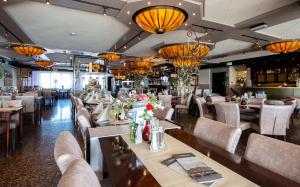 una sala da pranzo con tavoli, sedie e lampadari di Hotel Old Dutch a Volendam