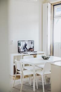 - une salle à manger blanche avec une table et des chaises blanches dans l'établissement Estação Ferroviária de Mondim de Basto, à Castelbuono