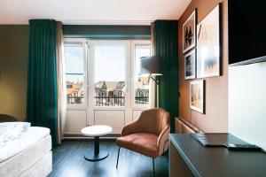 una camera con un letto e una sedia e una finestra di Hotel Old Dutch a Volendam