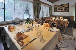 a dining room with a table with a white table cloth at Seminarhotel Linde Stettlen in Bern