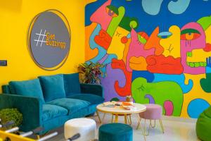 a living room with a couch and a colorful wall at ArtBuzz Jaipur in Jaipur