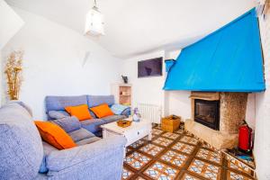 sala de estar con sofá azul y chimenea en Casa Rural La Pontezuela, en El Puente del Arzobispo