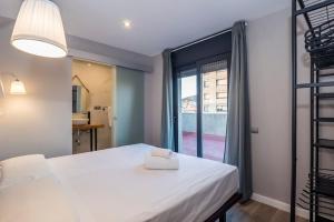 una camera da letto con un grande letto bianco e una finestra di BeBarceloner Sant Andreu Apartments - 1 bedroom with terrace a Barcellona