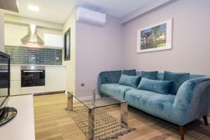 un soggiorno con un divano blu e un tavolo di BeBarceloner Sant Andreu Apartments - 1 bedroom with terrace a Barcellona