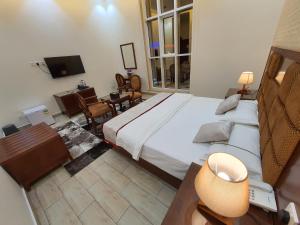 a bedroom with a large bed and a living room at فندق درة الرؤية in Jeddah
