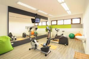 un gimnasio con bicicletas estáticas y una sala con TV en Kurhotel Bad Rodach an der ThermeNatur, en Bad Rodach