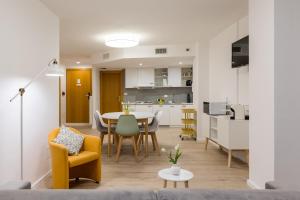 a living room with a table and chairs and a kitchen at MAMA Apartments in Riva del Garda