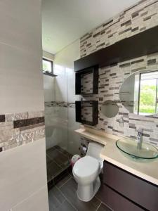 ein Badezimmer mit einem weißen WC und einem Waschbecken in der Unterkunft Casa Quinta Tres Marías in Villavicencio