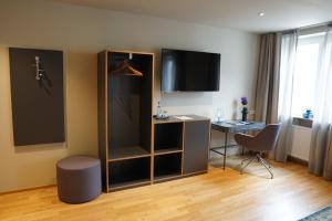 a hotel room with a desk and a tv at Gasthof Adler in Bad Wurzach