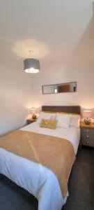 um quarto com uma cama grande e um cobertor castanho em Rammal Lodge - Entire home, self catering apartment in Inverness em Inverness