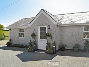a house with potted plants in front of it at Cefn Helyg Bach - 28453 in Cemaes Bay