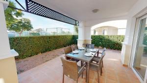 Une table à manger et des chaises sont disponibles sur la terrasse. dans l'établissement Casa Boqueron S-A Murcia Holiday Rentals Property, à Roldán