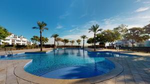 une grande piscine avec des palmiers et des bâtiments dans l'établissement Casa Boqueron S-A Murcia Holiday Rentals Property, à Roldán