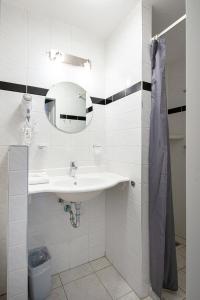 Baño blanco con lavabo y espejo en Hotel Old Dutch, en Volendam