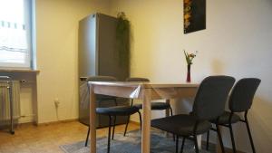 a room with a table with chairs and a refrigerator at Ferienwohnung Einberger-Schinabeck in Grafenau