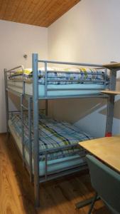 two bunk beds in a room with a table at Ferienwohnung Einberger-Schinabeck in Grafenau