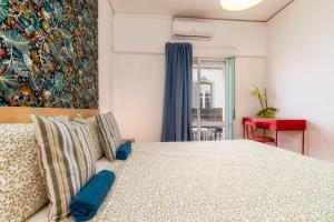 1 dormitorio con 1 cama grande con almohadas azules en Happen!ng 2 en Faro