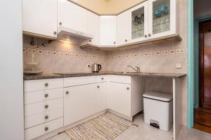 una cocina con armarios blancos y fregadero en Happen!ng 2, en Faro