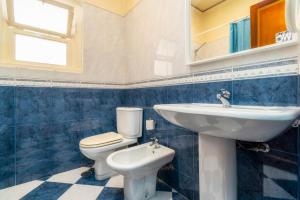 baño azul y blanco con aseo y lavamanos en Happen!ng 2 en Faro
