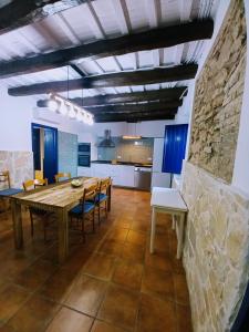a kitchen and dining room with a wooden table and chairs at Masia St Salvador 1582 in Cubelles