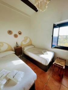 a room with two beds and a window at Masia St Salvador 1582 in Cubelles