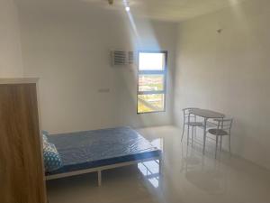a room with a bed and two chairs and a window at Ziem Rooms Cebu in Sudtungan