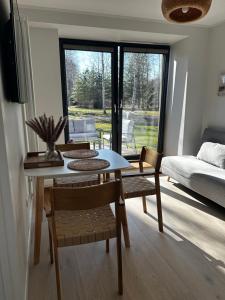 uma sala de estar com uma mesa e cadeiras e um sofá em Albatross Getaway by the sea, SPA and forest with a Terrace em Ķesterciems
