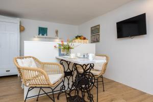 a dining room with a white table and chairs at Charming Studio apartment at House Rustica with terrace and nearby parking in Punat