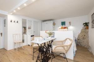 a kitchen and dining room with a table and chairs at Charming Studio apartment at House Rustica with terrace and nearby parking in Punat