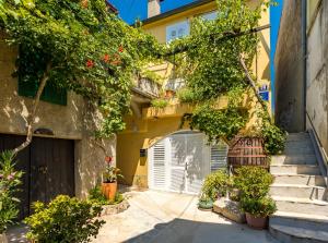 a building with a gate and stairs and flowers at Charming Studio apartment at House Rustica with terrace and nearby parking in Punat