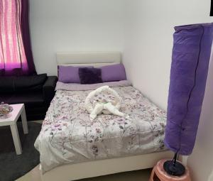 ein kleines Schlafzimmer mit einem Bett mit violetter Bettwäsche in der Unterkunft The Purple Place in Abu Dhabi