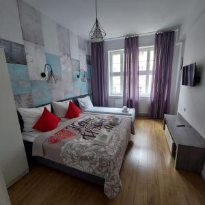 a bedroom with a large bed with red pillows at Kazimierz Old Town Apartments in Krakow