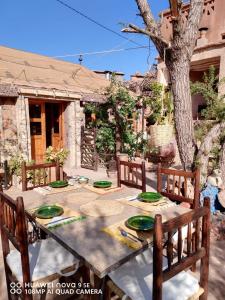 a table with green plates on it in a yard at Dar Isselday in Tisselday