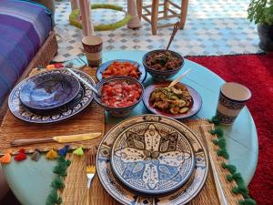 einen Tisch mit Teller mit Lebensmitteln darüber in der Unterkunft RIAD SULTAN Marrakech in Marrakesch
