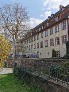 a large building with a fence in front of it at Apartment am Zolltor in Wertheim