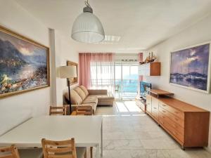 ein Wohnzimmer mit einem Tisch und einem Sofa in der Unterkunft Seafront apartment in Blanes in Blanes