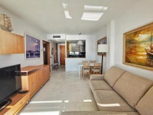 a living room with a couch and a television at Seafront apartment in Blanes in Blanes