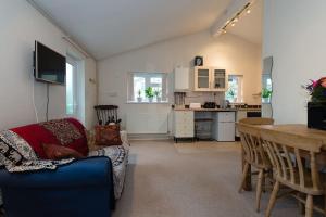 a living room with a couch and a table and a kitchen at Bristol self-catering studio+kitchen+parking in Bristol