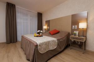 a hotel room with a bed with a tray of fruit on it at Chambéry Appart'S in Chambéry