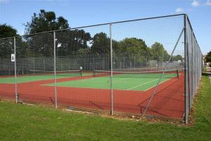 two people playing tennis on a tennis court at Luxury 1 bed studio at Florence House, in the centre of Herne Bay and 300m from beach in Herne Bay