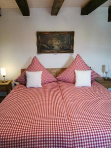 a bed with a red and white checkered blanket at Apartment am Zolltor in Wertheim