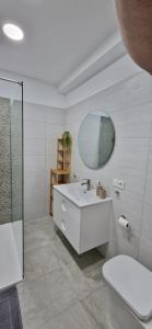 a white bathroom with a sink and a mirror at Apartament Meduza in Alicante