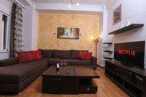 a living room with a couch and a tv at Irene house tenis club in Ágios Rókkos